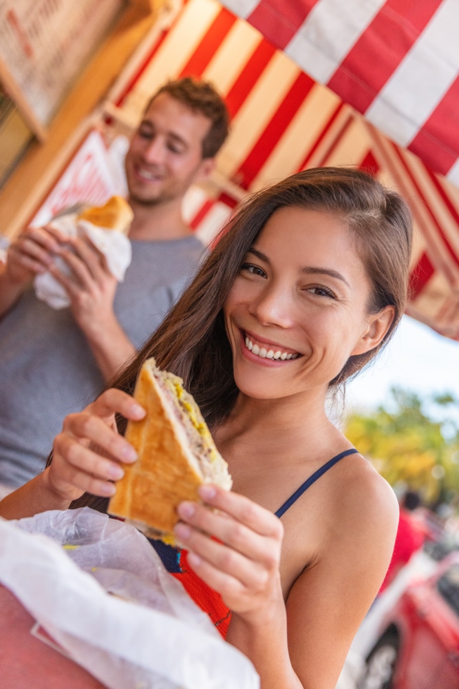 Happy,Asian,Girl,Eating,Cuban,Sandwich,At,Local,Cafe,Restaurant